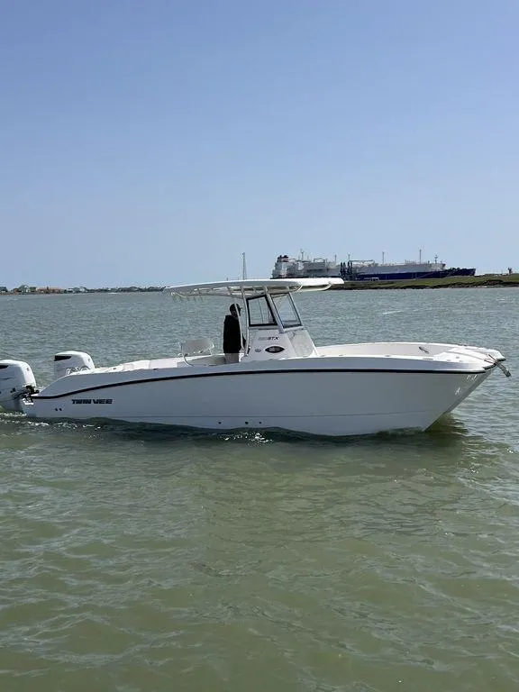 Slide: The Image of 2024 Twin Vee 280 STX boat on calm water, clear sky background. - 31
