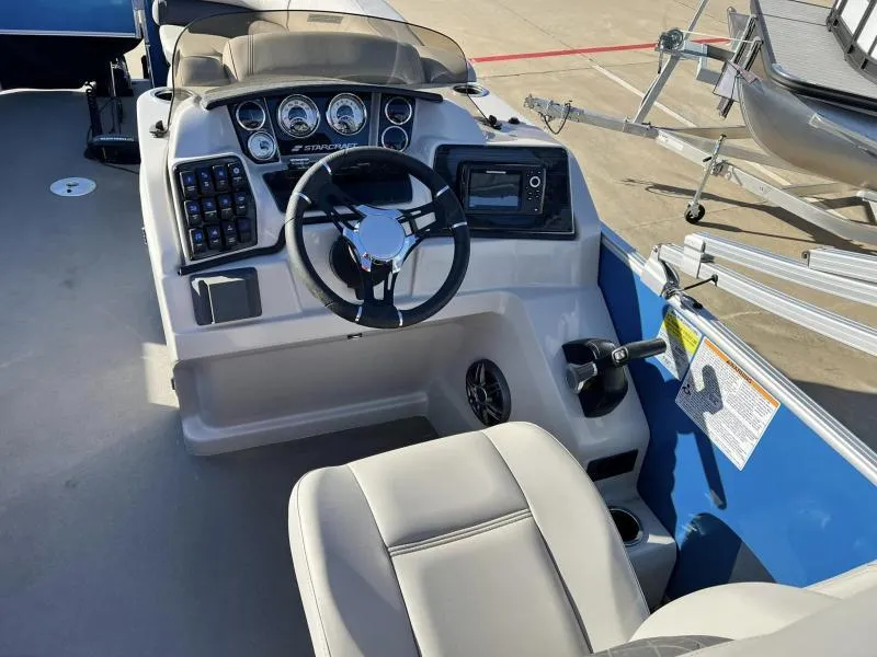 Slide: The Image of 2023 Starcraft CX 23 FD boat cockpit with steering wheel, control panel, and seating. - 12