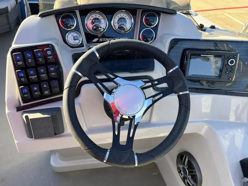 Slide: The Image of 2023 Starcraft CX 23 FD boat dashboard with steering wheel, gauges, and navigation system. - 13