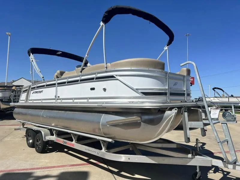 Slide: The Image of 2023 Starcraft CX 25 DL BAR pontoon boat on a trailer under a clear blue sky. - 6