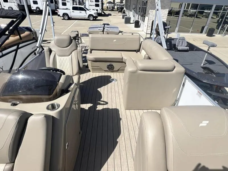 Slide: The Image of 2023 Starcraft CX 25 DL BAR boat interior with beige seating and steering console. - 8