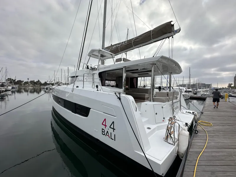 Slide: The Image of 2024 Bali 4.4 catamaran docked at a marina under cloudy skies. - 13