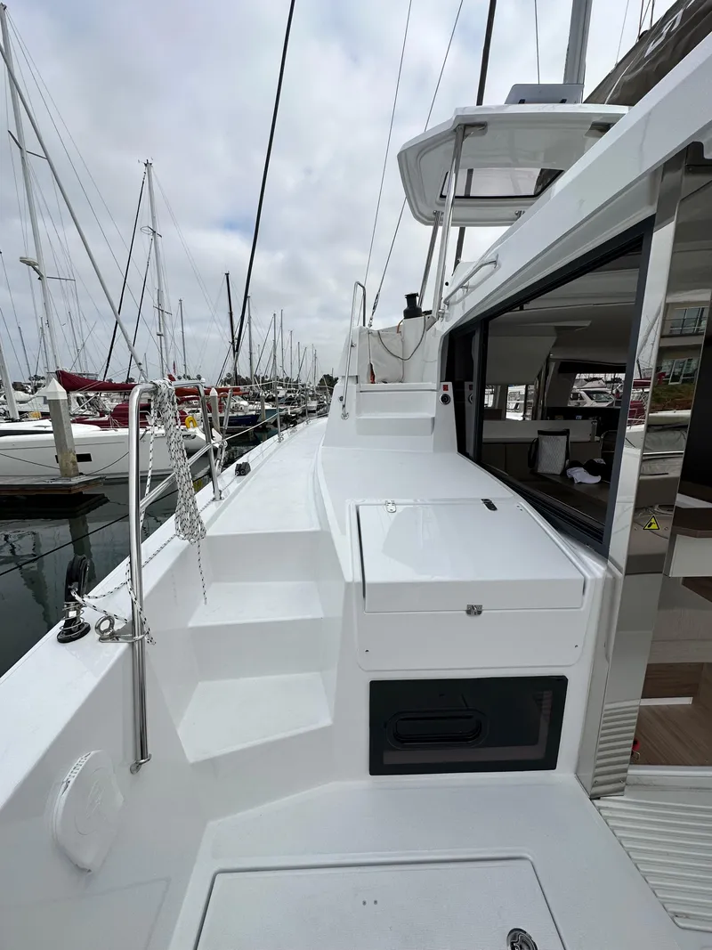 Slide: The Image of 2024 Bali 4.4 yacht docked at marina, showcasing deck and cabin entrance. - 16