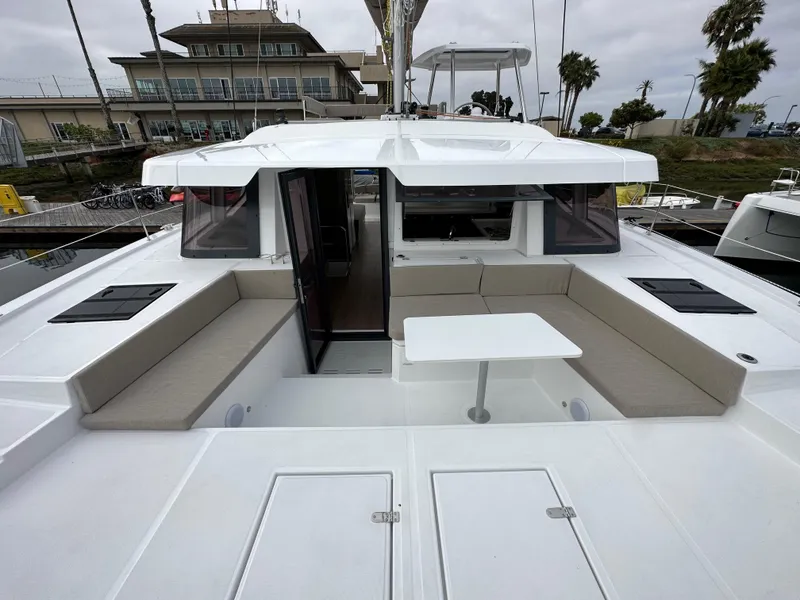 Slide: The Image of 2024 Bali 4.4 yacht with spacious outdoor seating and table, docked at marina. - 31