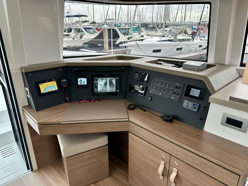Slide: The Image of 2024 Bali 4.4 yacht control station with modern navigation equipment and marina view. - 44