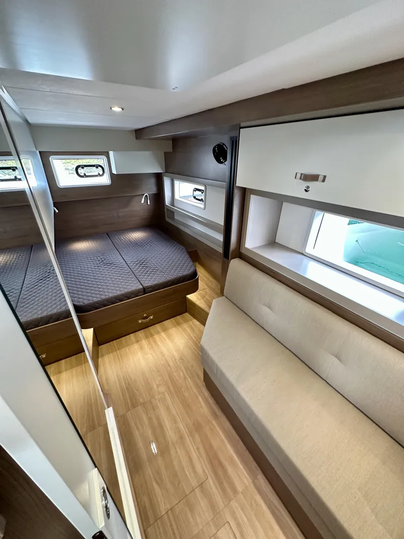 Slide: The Image of 2024 Bali 4.4 yacht interior cabin with bed, sofa, and windows. - 49