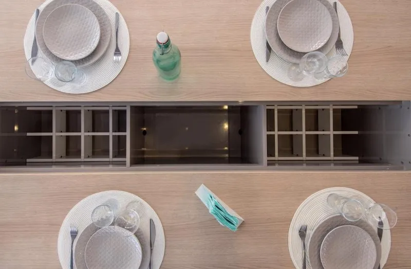 Slide: The Image of Elegant dining setup on Bali 5.4 yacht, 2025 model, featuring modern tableware and bottle. - 17