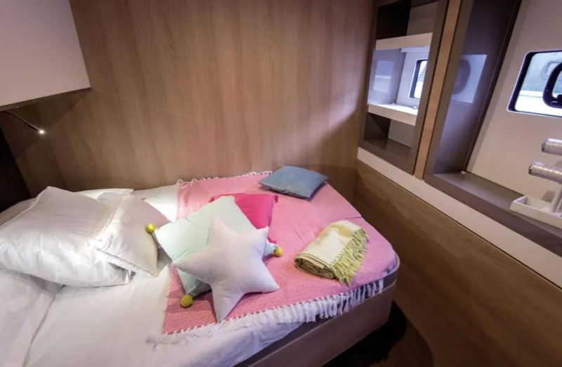 Slide: The Image of Cozy bedroom in 2025 Bali 5.4 yacht with colorful pillows and wooden interior. - 21