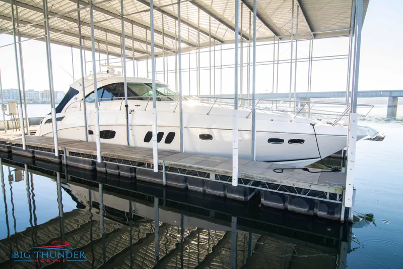 Slide: The Image of 2010 Sea Ray 540 Sundancer yacht docked under a covered marina. - 1