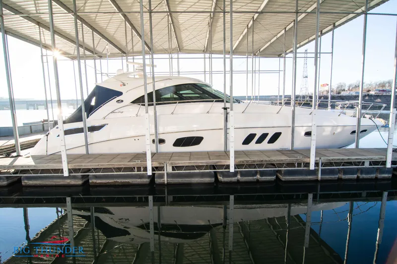 The Image of 2010 Sea Ray 540 Sundancer yacht docked under a covered marina. - 0
