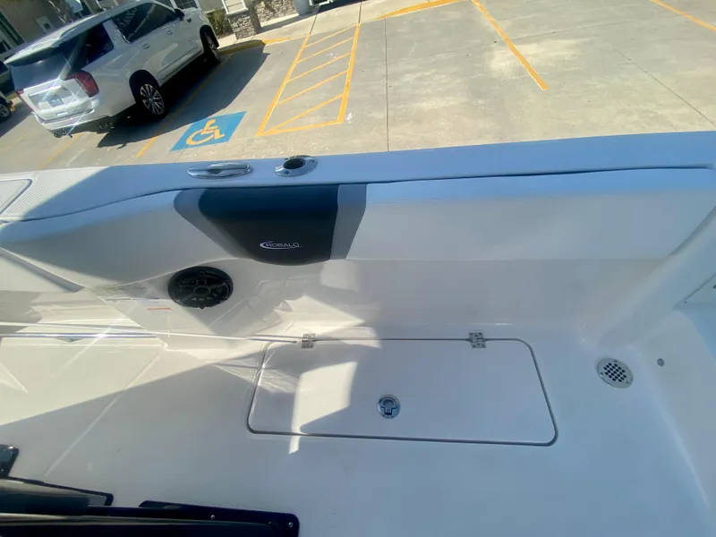 Slide: The Image of 2026 Robalo R250 boat interior with storage compartment and speaker, parked near a handicap space. - 17