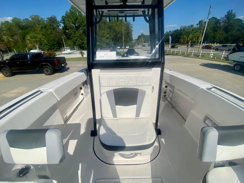 Slide: The Image of 2026 Robalo R250 boat interior with seating, parked outdoors. - 25