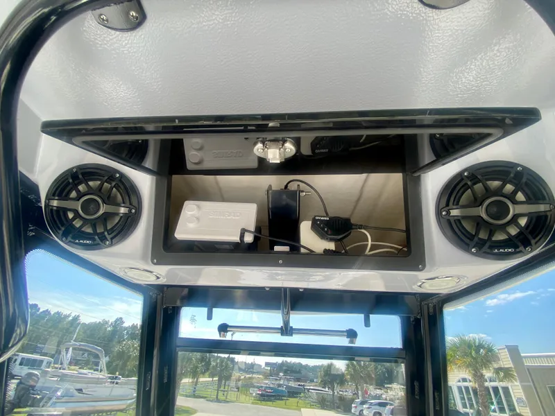 Slide: The Image of 2026 Robalo R250 boat interior with speakers and electronic equipment storage. - 26