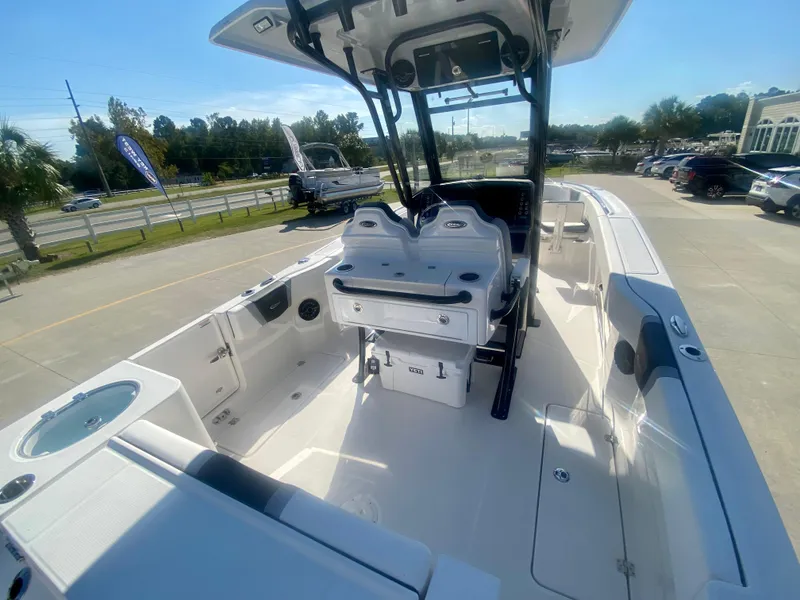 Slide: The Image of 2026 Robalo R250 boat interior with seating and console, parked outdoors on a sunny day. - 7