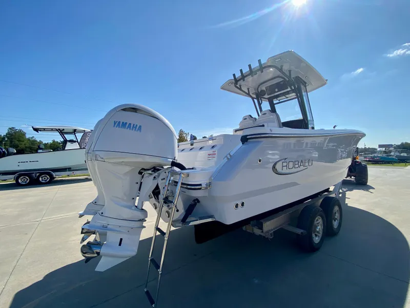 Slide: The Image of 2026 Robalo R250 boat with Yamaha engine on trailer under clear blue sky. - 2