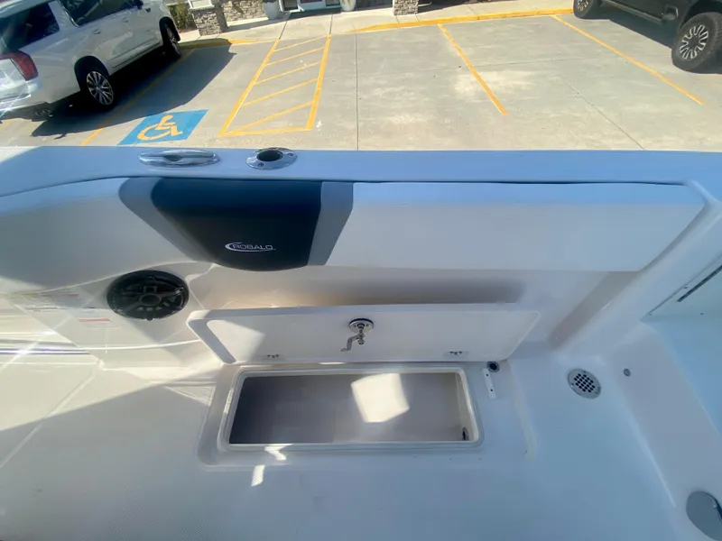 Slide: The Image of 2026 Robalo R250 boat interior with storage compartment and speaker, parked in a lot. - 20