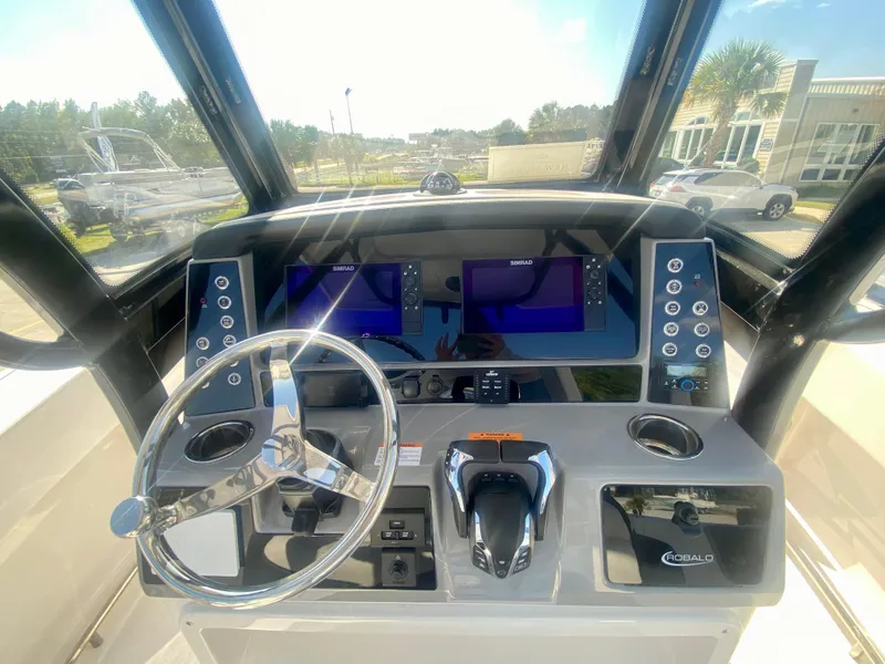 Slide: The Image of 2026 Robalo R250 boat dashboard with steering wheel and dual navigation screens. - 21