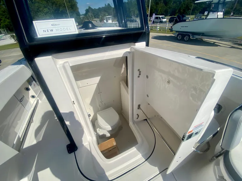 Slide: The Image of 2026 Robalo R250 boat interior with open storage compartment and visible toilet. - 27