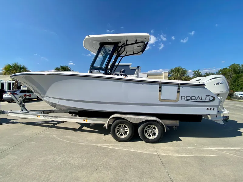 Slide: The Image of 2026 Robalo R250 boat on trailer, side view, clear sky background. - 0