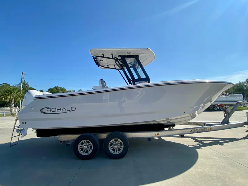 Slide: The Image of 2026 Robalo R250 boat on trailer under clear blue sky. - 1