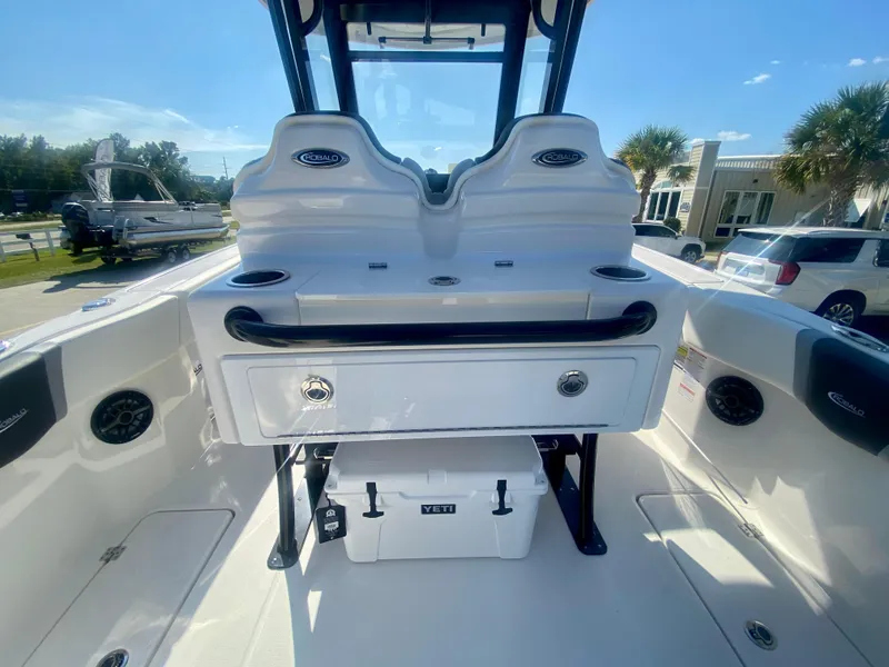 Slide: The Image of 2026 Robalo R250 boat interior with storage and cooler, under clear blue sky. - 14