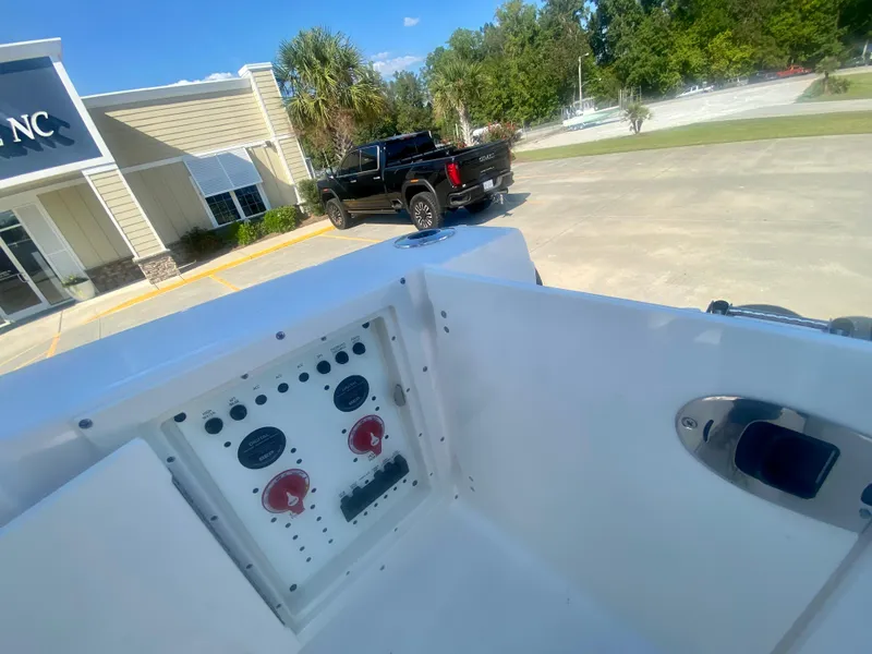 Slide: The Image of 2026 Robalo R250 boat dashboard with control panel, parked truck, and building in background. - 9