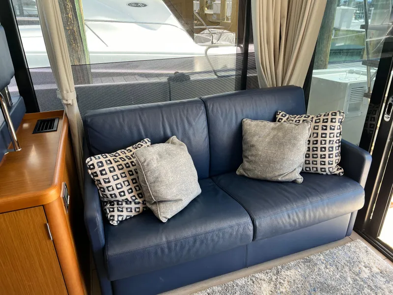 Slide: The Image of Interior of 2021 Beneteau Swift Trawler 35 with blue leather sofa and decorative pillows. - 13