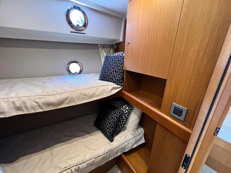Slide: The Image of 2021 Beneteau Swift Trawler 35 cabin with bunk beds and wooden cabinetry. - 23