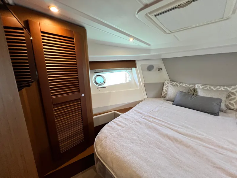 Slide: The Image of 2021 Beneteau Swift Trawler 35 bedroom with cozy bed and wooden wardrobe. - 29