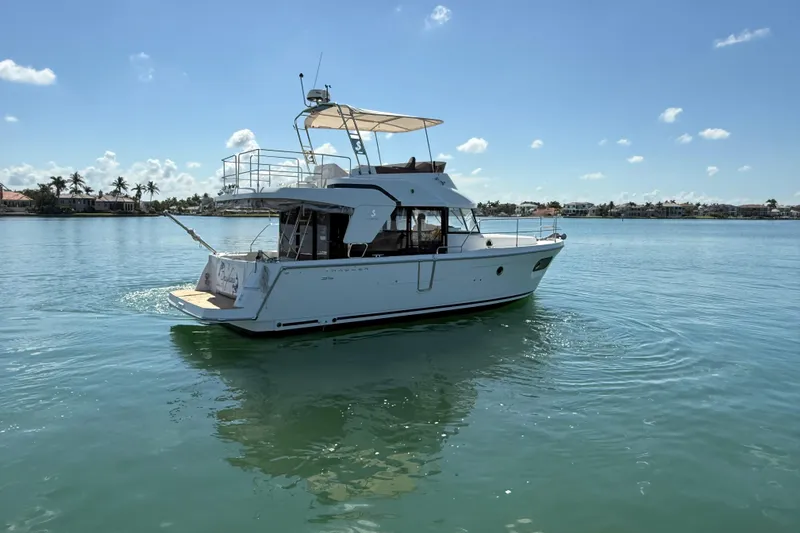 Slide: The Image of 2021 Beneteau Swift Trawler 35 cruising on calm waters under a clear blue sky. - 3