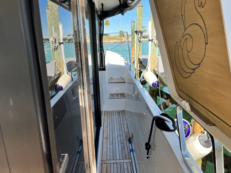 Slide: The Image of 2021 Beneteau Swift Trawler 35 side deck with wooden flooring and dock view. - 38