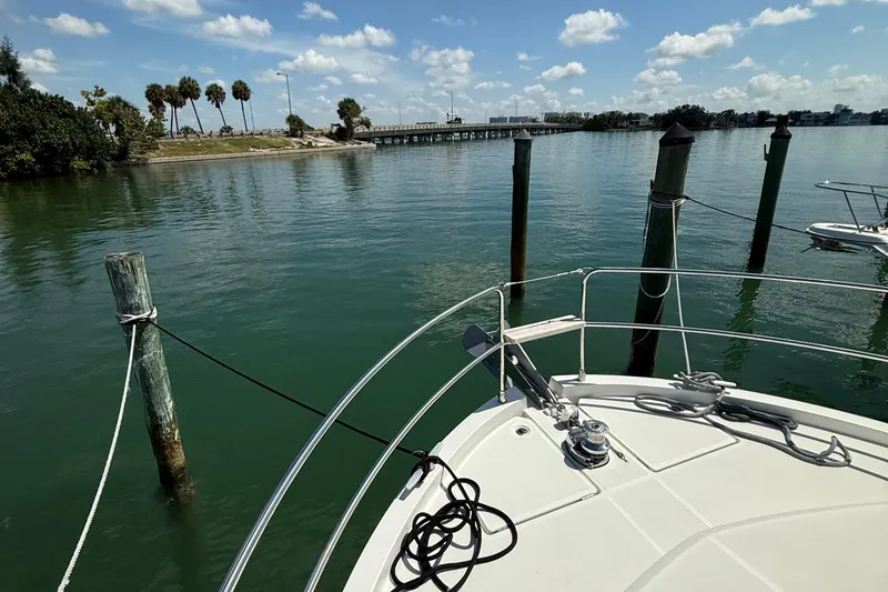 Slide: The Image of Bow of 2021 Beneteau Swift Trawler 35 docked in serene waters under blue sky. - 41