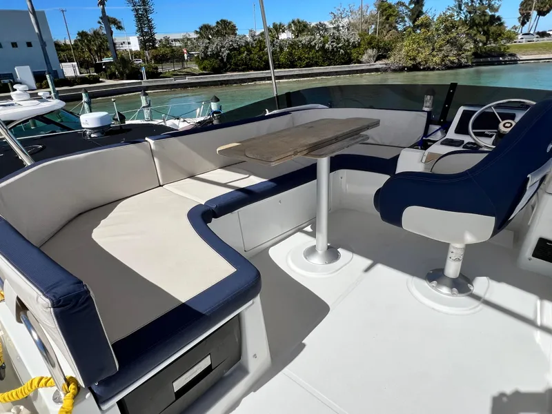 Slide: The Image of Beneteau Swift Trawler 35, 2021 model, outdoor seating area with table and helm station. - 49