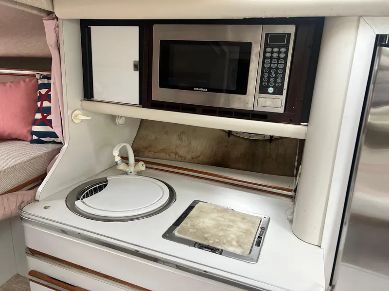 Slide: The Image of Compact kitchen area in a 1991 Cruisers Yachts Rouge 33 with microwave and sink. - 27
