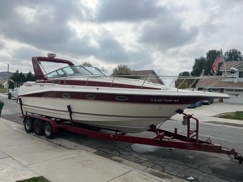 Slide: The Image of 1991 Cruisers Yachts Rouge 33 on a trailer in a residential area. - 3