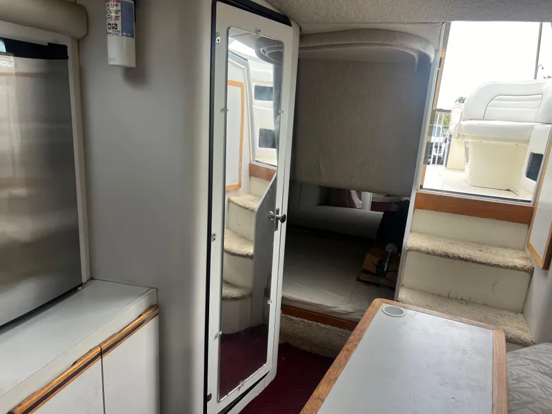 Slide: The Image of 1991 Cruisers Yachts Rouge 33 interior cabin with bed, table, and storage. - 30