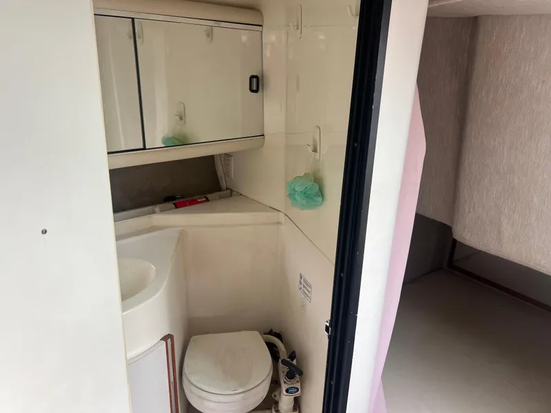 Slide: The Image of 1991 Cruisers Yachts Rouge 33 bathroom with sink, toilet, and storage cabinets. - 33