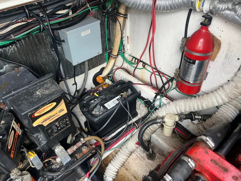 Slide: The Image of 1991 Cruisers Yachts Rouge 33 engine compartment with battery, wiring, and fire extinguisher. - 40