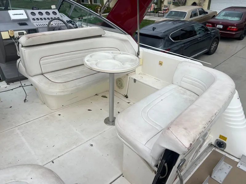Slide: The Image of 1991 Cruisers Yachts Rouge 33 interior seating area with table and dashboard. - 9