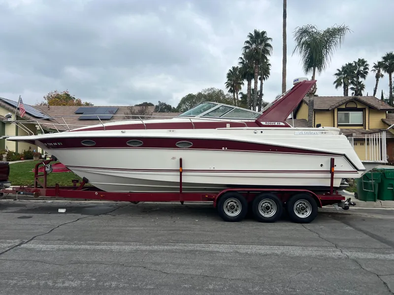 Slide: The Image of 1991 Cruisers Yachts Rouge 33 on a trailer in a residential area. - 1