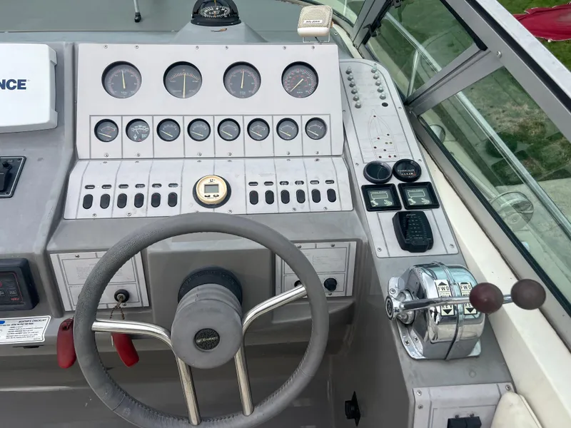 Slide: The Image of 1991 Cruisers Yachts Rouge 33 boat dashboard with steering wheel and control panel. - 13