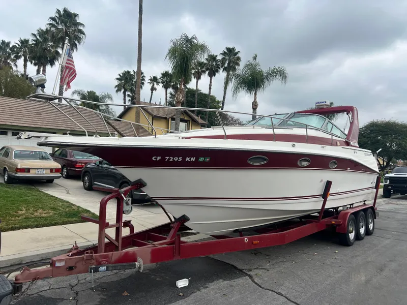 Slide: The Image of 1991 Cruisers Yachts Rouge 33 on a red trailer in a residential area. - 2