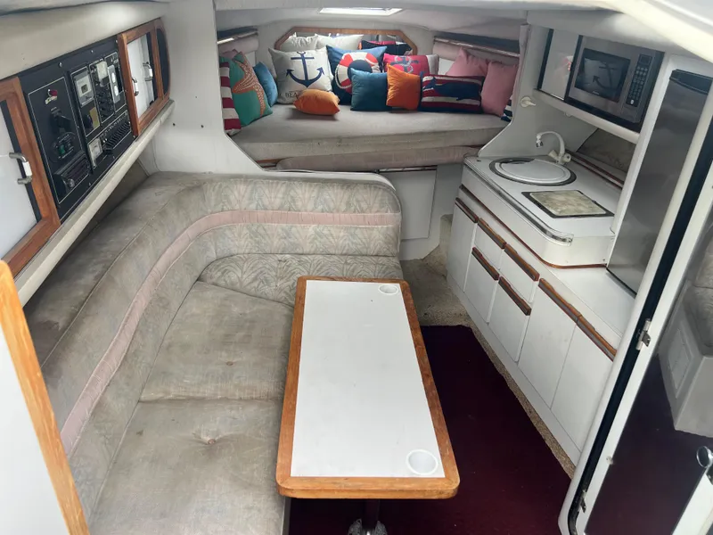 Slide: The Image of 1991 Cruisers Yachts Rouge 33 interior with seating, table, and galley area. - 21