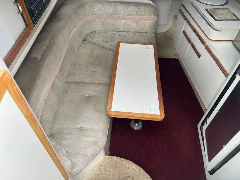 Slide: The Image of 1991 Cruisers Yachts Rouge 33 interior with cushioned seating and table. - 22