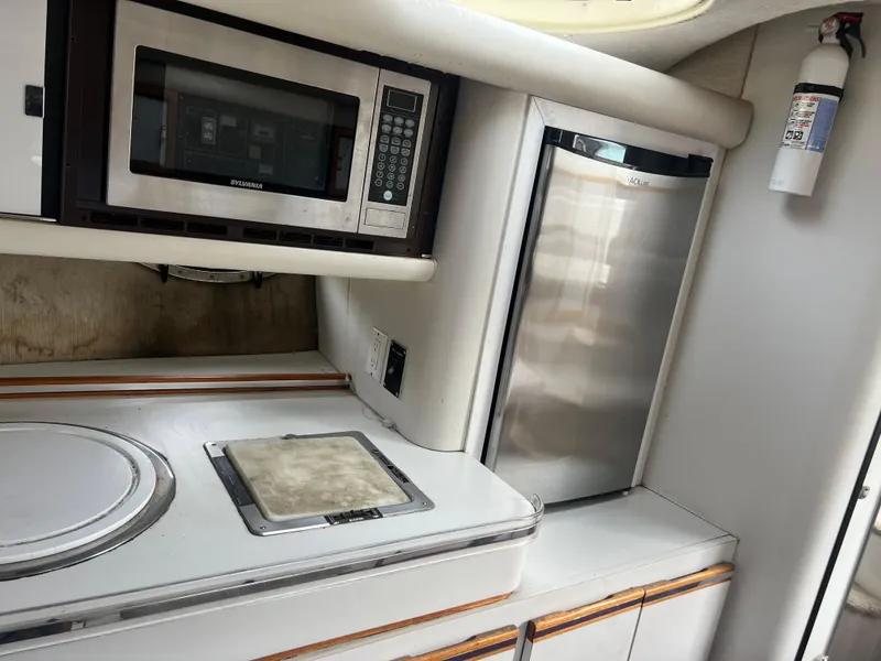 Slide: The Image of 1991 Cruisers Yachts Rouge 33 kitchen with microwave, fridge, and stove. - 29