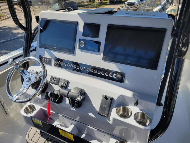 Slide: The Image of 2025 Key West 291 FS boat dashboard with dual screens and steering wheel. - 18
