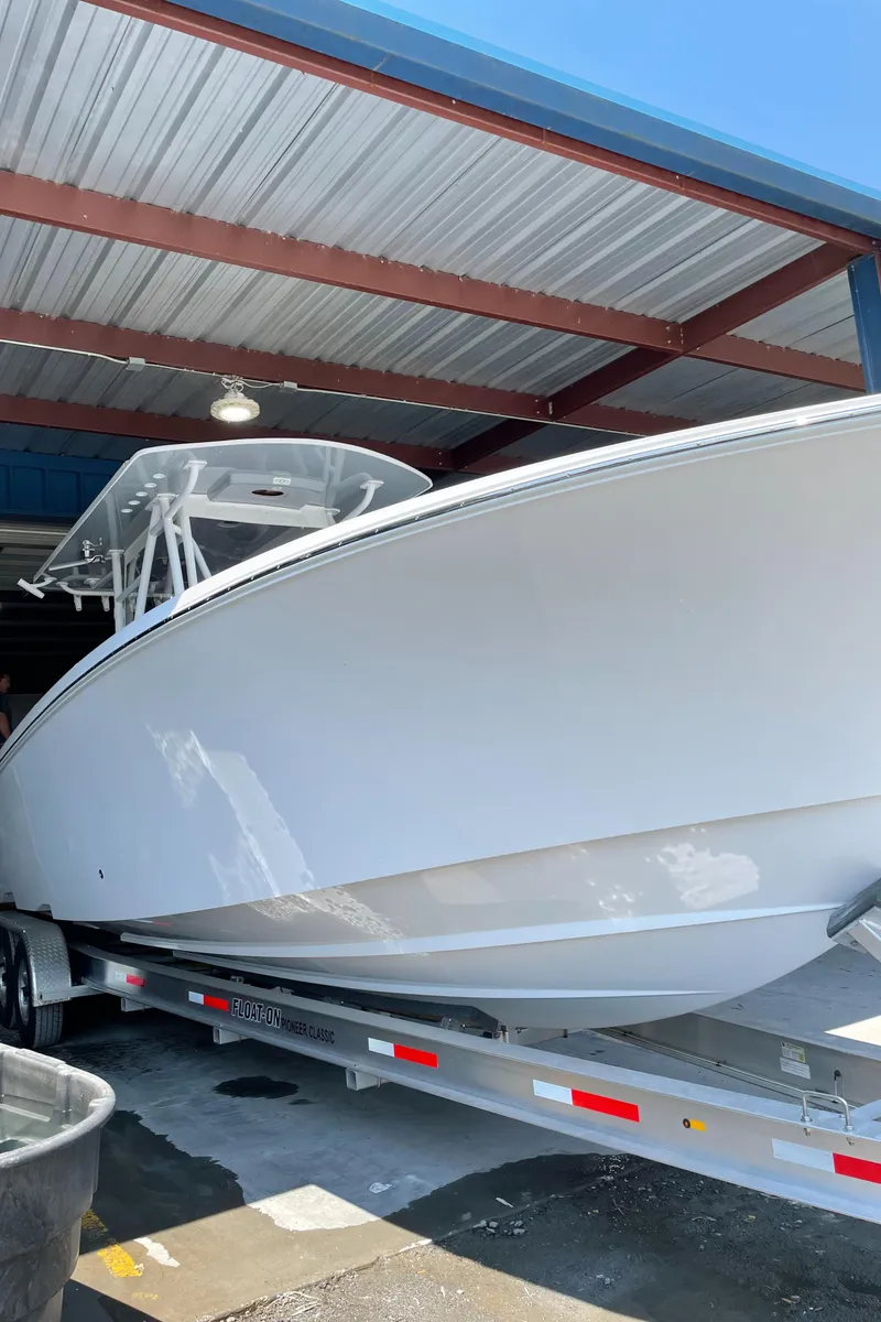 Slide: The Image of 2022 Invincible 36 Open Fisherman boat on a trailer in a covered storage area. - 12