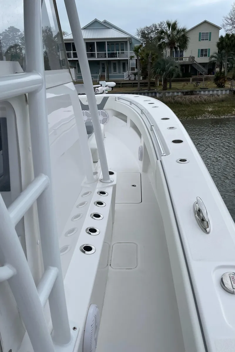 Slide: The Image of 2022 Invincible 36 Open Fisherman boat docked near waterfront homes. - 3