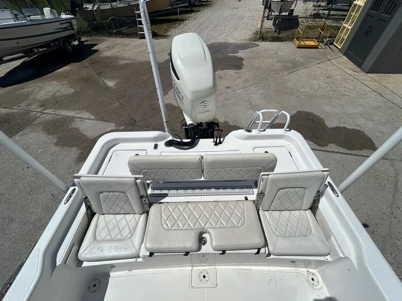 Slide: The Image of 2019 Blue Wave 2400 PureBay boat with white cushioned seating and outboard motor. - 29