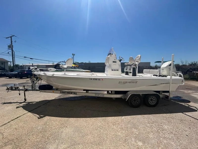 Slide: The Image of 2019 Blue Wave 2400 PureBay boat on a Continental trailer in a sunny outdoor setting. - 3
